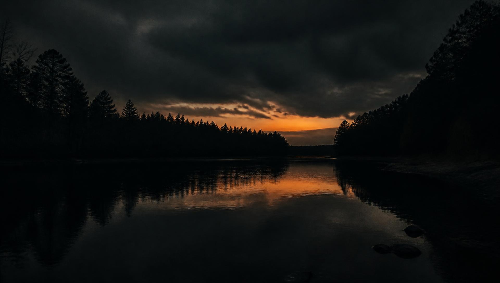 Black river at dusk beneath a storm sky in rural Georgia